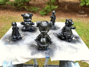 4 figurines from thrift stores painted black as creepy haunted Halloween decor Sadie Seasongoods
