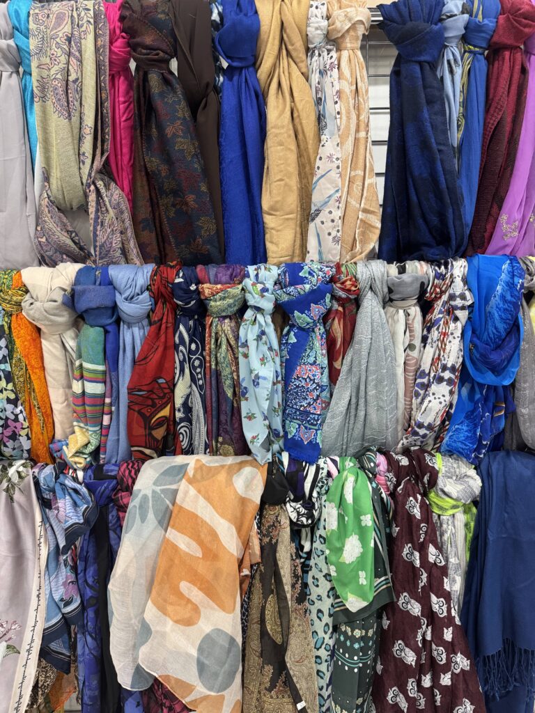 Sustainable & Affordable Thrift Gift Ideas from Goodwill Alberta 11 Colourful scarves displayed on racks at Goodwill SouthPark in Edmonton